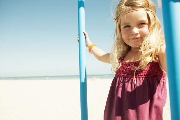 Sorridente ragazza bionda sulla spiaggia soleggiata