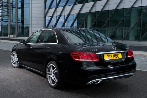 Mercedes-Benzes e 350 nero parcheggiato strada accanto all edificio per uffici