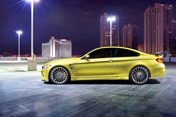 Giallo BMW M4 sullo sfondo della città di notte