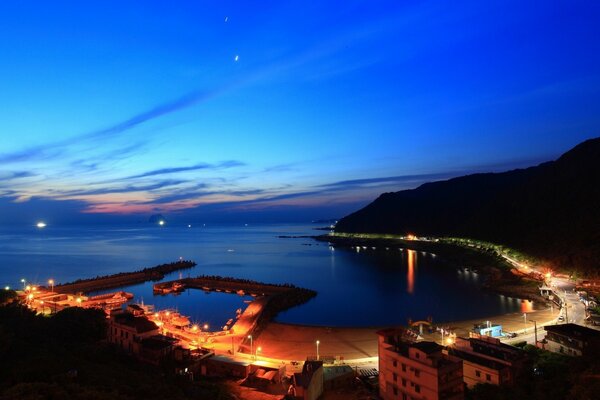 Città notturna vicino al mare. Tramonto