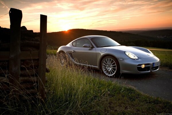 Porsche Cayman grigia al tramonto