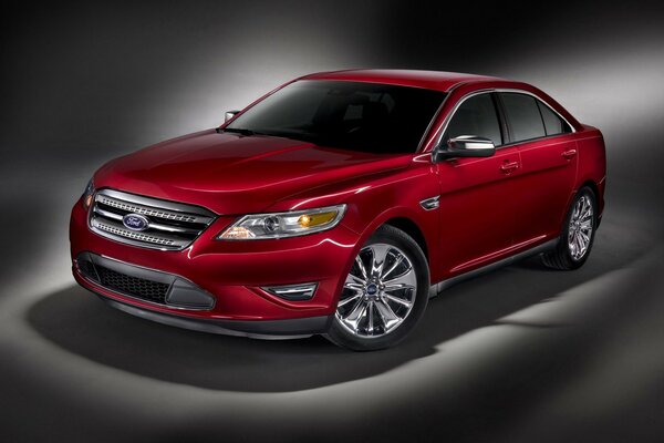 Auto di lusso di colore rosso su sfondo grigio. Rosso scintillante Ford Taurus