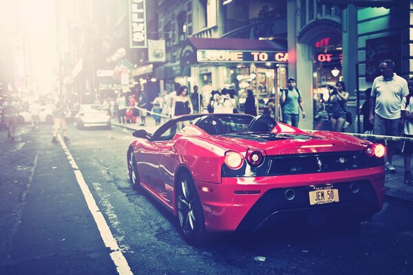 Automobile di Ferrari nel colore rosso sulla via della città