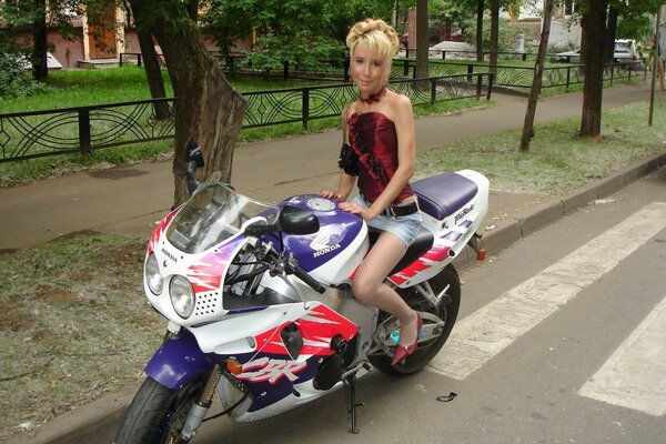 Donna in minigonna su un motociclo sulla strada