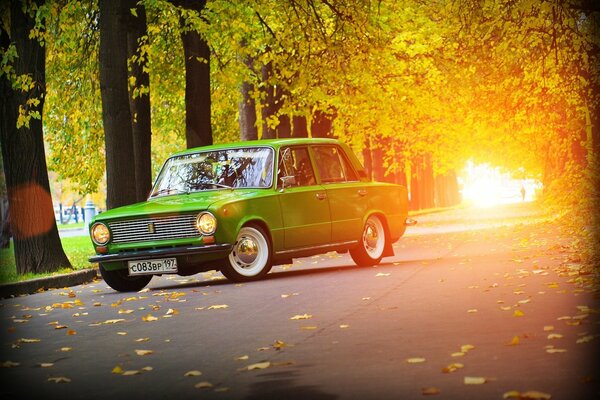 Auto verde Lada sullo sfondo della strada d autunno