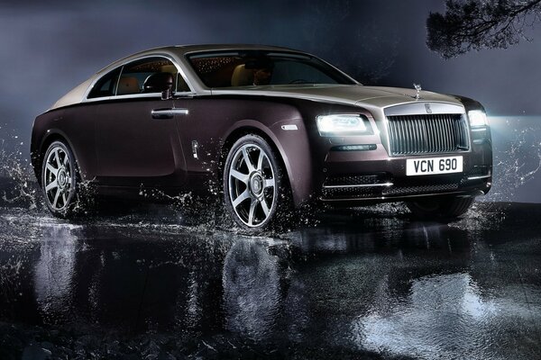 Auto Rolls Royce sulle pozzanghere sulla strada notturna