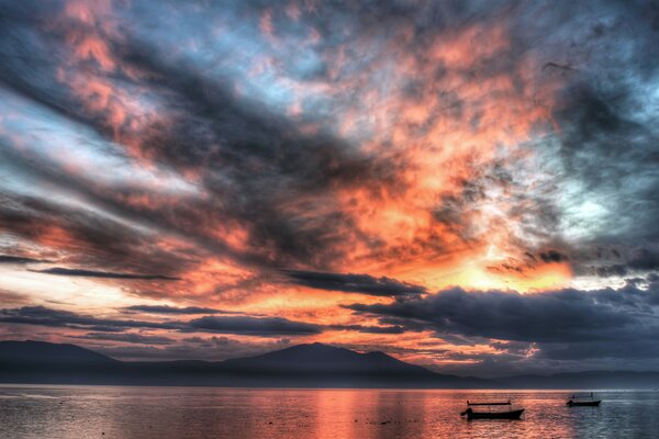 Barche sulla superficie del mare sotto il cielo al tramonto