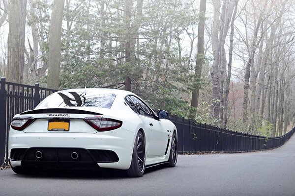 Maserati Bianco Italia su sfondo di recinzione