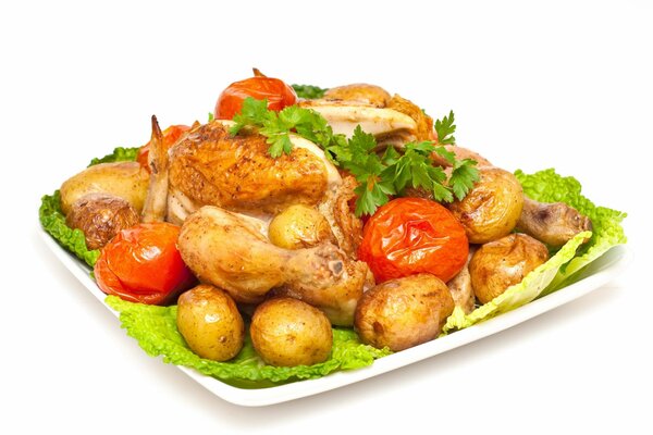 Patate, pollo e pomodori su un piatto