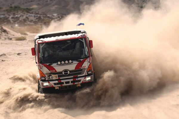 Camion sportivo che polverizza sulla pista sulla sabbia