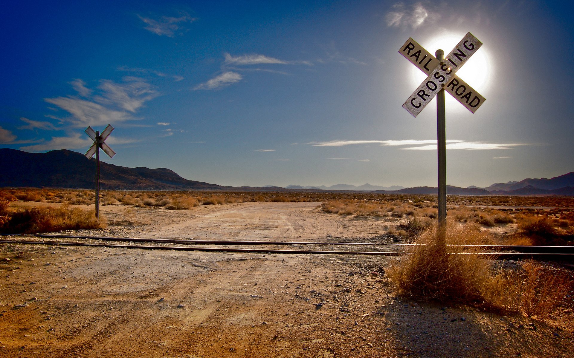 paesaggi erba deserto deserti ferrovia ferrovia rotaie traversine sole montagne nuvole nuvola strada strade incroci