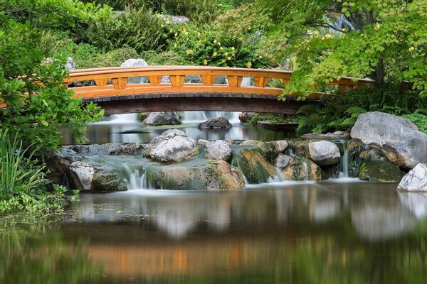 Ponte nel giardino piccole cascate versano dalle pietre