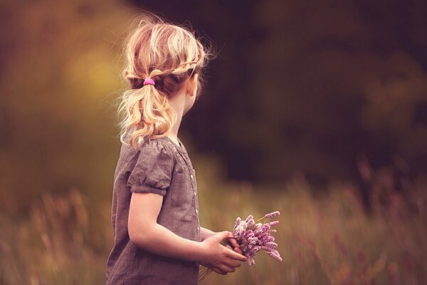 Foto di una ragazza con fiori in mezzo alla foresta