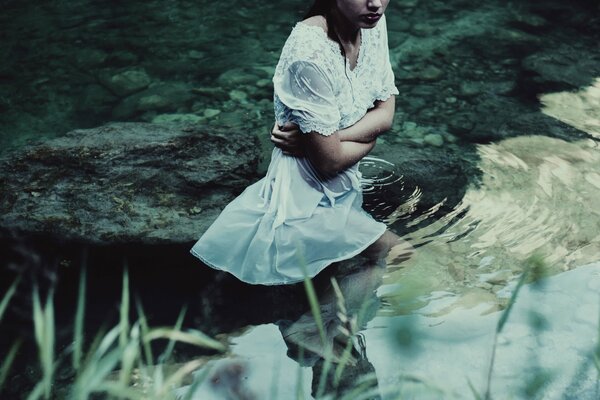 Servizio fotografico in acque tranquille, ragazza in abito bianco