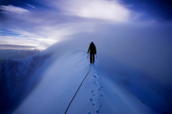 Scalatore che cammina su montagne innevate