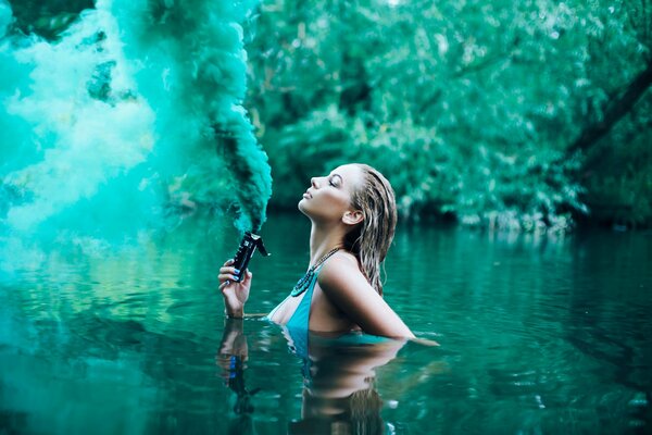La ragazza nel lago emette fumo verde