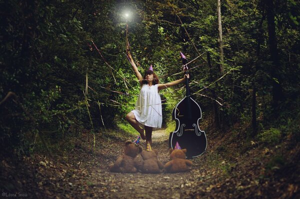 Ragazza con contrabbasso nella foresta