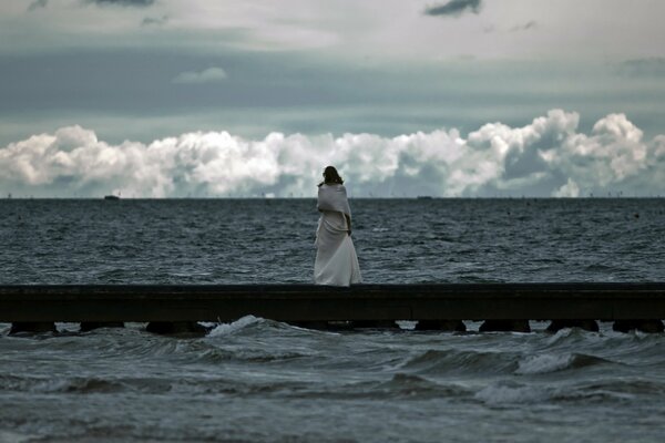 Ragazza che guarda il mare impetuoso