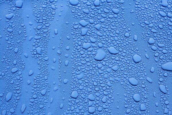 Gocce di diverse dimensioni sulla superficie blu