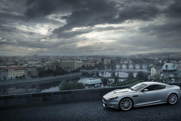 Aston Martin sullo sfondo di una città con nuvole