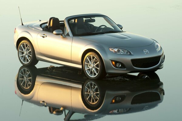 Mazda grigia su una decappottabile si trova sulla superficie dello specchio