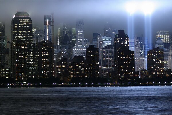 Luci notturne di New York con fasci di luce