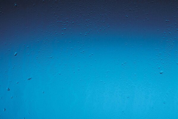 Gocce di pioggia su sfondo blu finestra