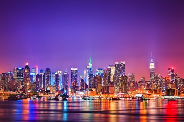 Le luci notturne di Manhattan si riflettono nel fiume Hudson