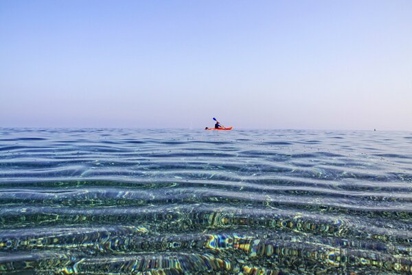 Uomo in canoa nuota nel mare