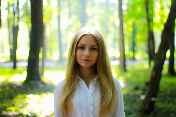 Bella ragazza sullo sfondo della natura verde in estate
