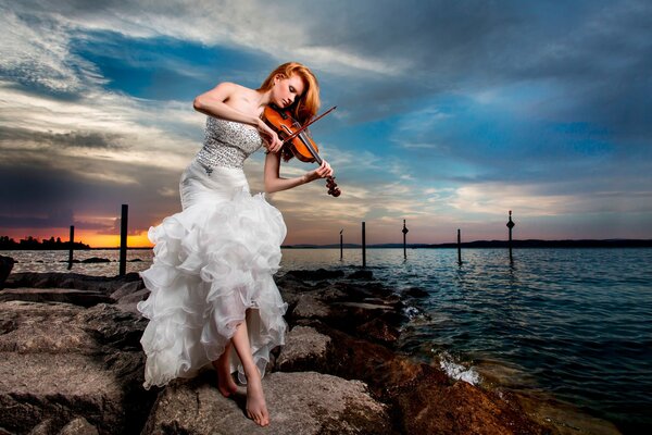 Ragazza in abito bianco suona il violino