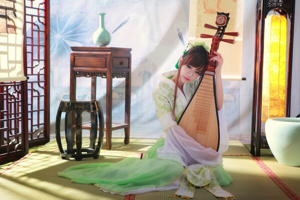 Ragazza asiatica che suona musica su uno strumento