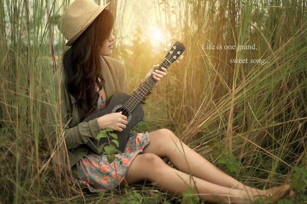 Chitarra nelle mani di una ragazza nella natura