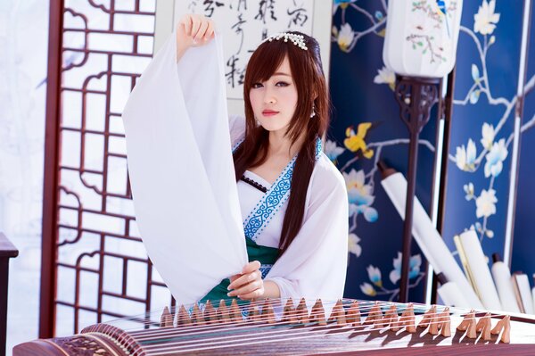 Ragazza asiatica in bianco con strumento musicale