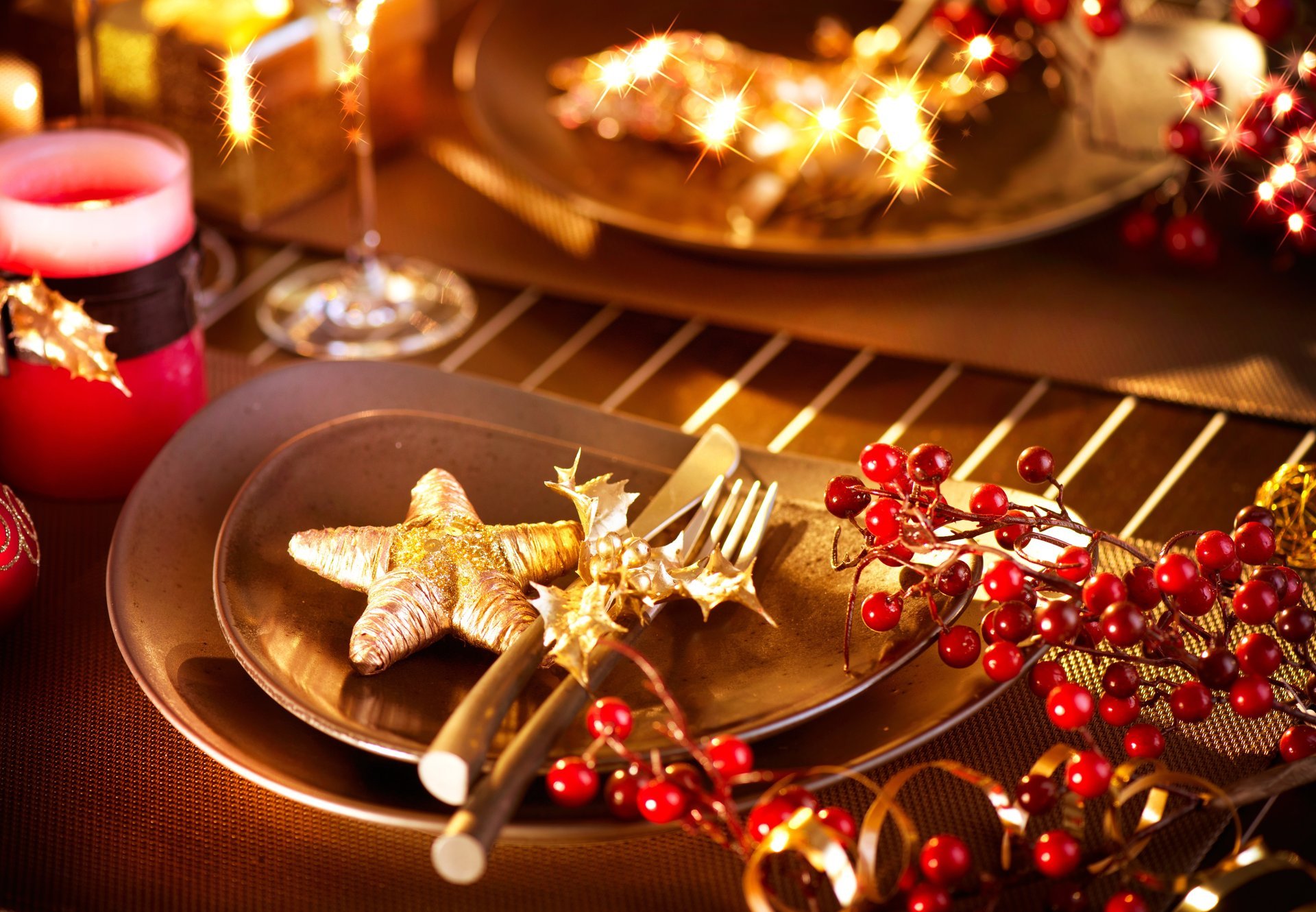 tavolo festivo candele piatti figurine stella bacche rosso agrifoglio inverno nuovo anno natale