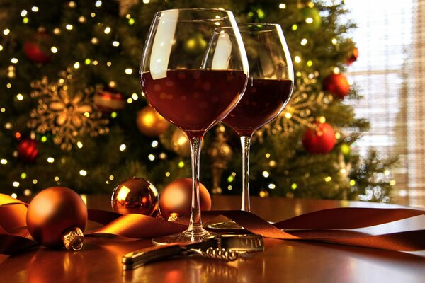 Decorazione festiva della tavola con palle e bicchieri di vino