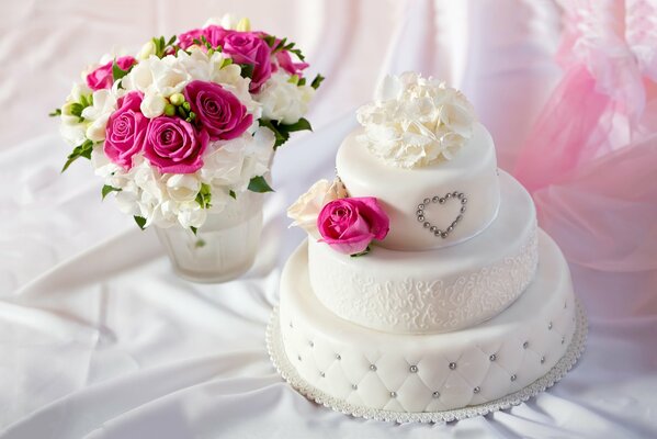 Torta nuziale con bouquet di fiori in piedi sul tavolo