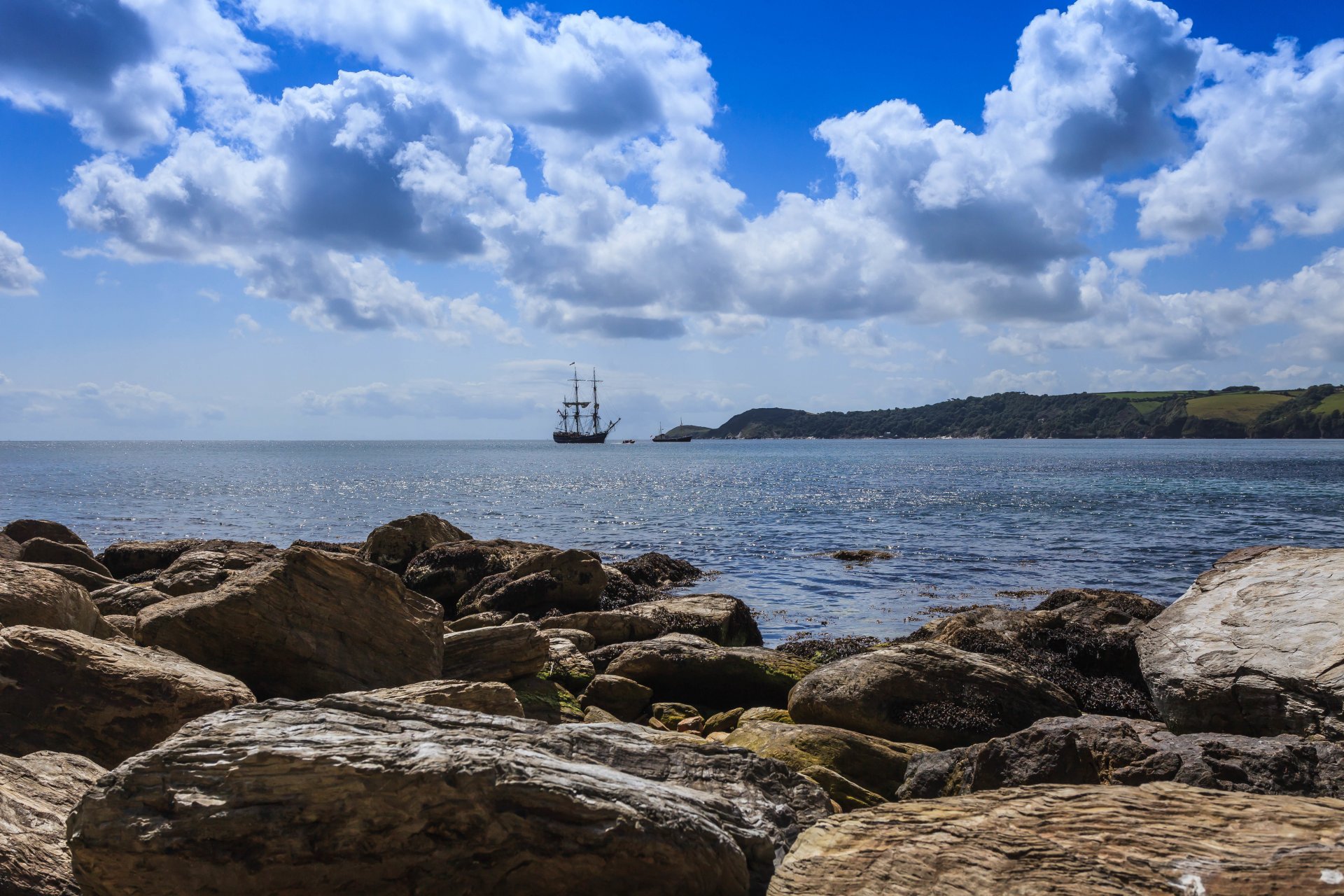 mare costa pietre nave barca a vela cielo nuvole