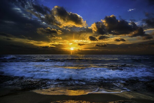 Il sole si fa strada attraverso le nuvole sopra l oceano