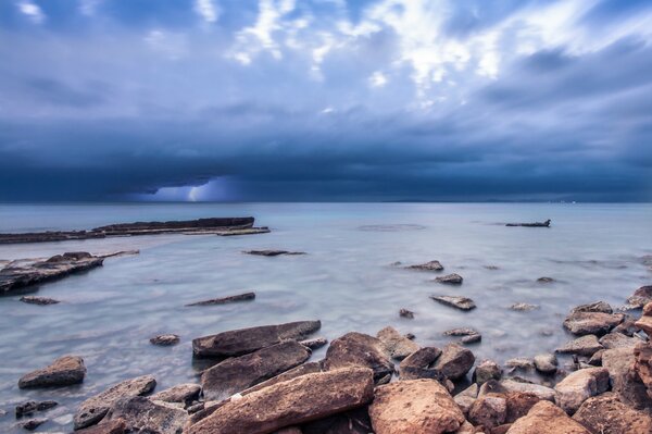 Rocce sull oceano sotto il cielo blu