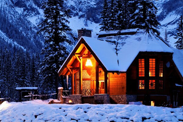 Casa nella natura invernale tra montagne e alberi.