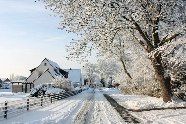 Tranquilla strada innevata con case bianche