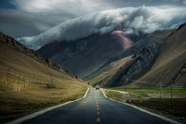 Montagne tibetane vicino alla strada sotto le nuvole