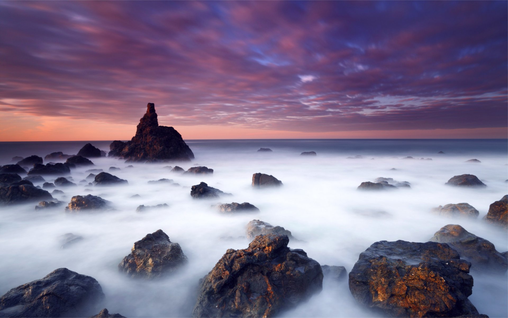 sera mare oceano costa pietre blu cielo nuvole arancione tramonto
