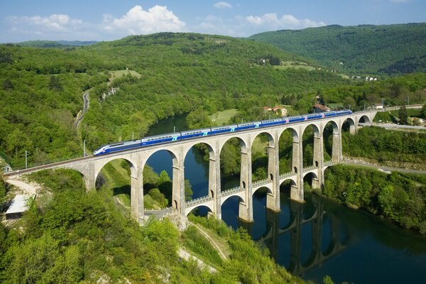 Treno azzurro che corre sopra il ponte francese