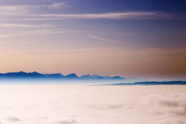 Fitta nebbia e cime delle montagne alpine