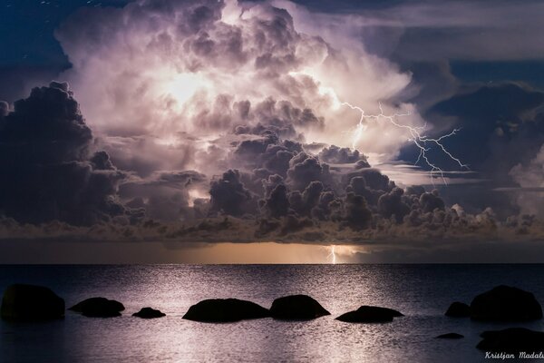 Nuvola notturna con fulmine sul mare